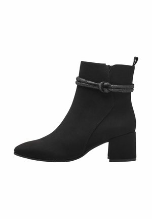 Black suede ankle boot with a pointed toe, chunky heel, and a knotted decorative strap around the ankle. Side zipper for easy wear.
