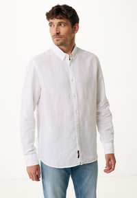 Witte linnen overhemd met knopen, een kraag, lange mouwen en een gebogen zoom. Minimalistisch ontwerp met subtiele textuur en geen patronen.