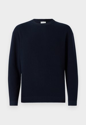 Marineblå ribbestrikket genser med rund hals, lange ermer og en avslappet passform. Myk tekstur, minimalistisk design og ingen synlige mønstre.