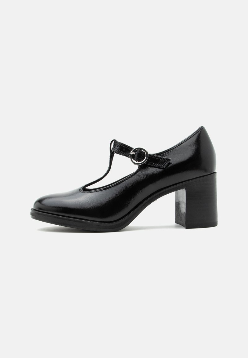 Chaussure Mary Jane en cuir verni noir avec bride en T, bout arrondi et talon épais sur fond blanc.