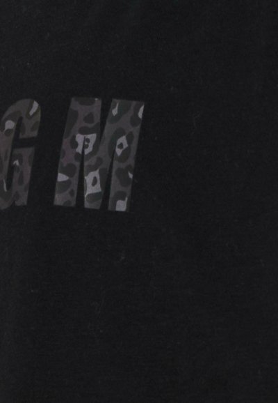 Zwarte stof met vet, grote letters "M" in een grijs luipaardpatroon. De textuur lijkt glad met een lichte glans.