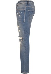 Kitsad, kulunud sinised teksad, mis on varustatud põlveribadega, kergelt pleekinud ning klassikalise viie tasku disainiga. Valmistatud denimkangast.