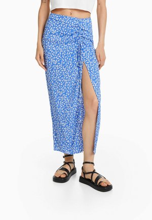 Blå blomster midi nederdel med rynker foran og høj slids, båret med sorte remsandaler og hvid cropped top.