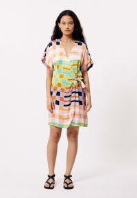 Kleurrijke patchwork jurk met brede mouwen, een V-hals en een strik in de taille. Bevat vierkanten in pastel- en levendige kleuren.