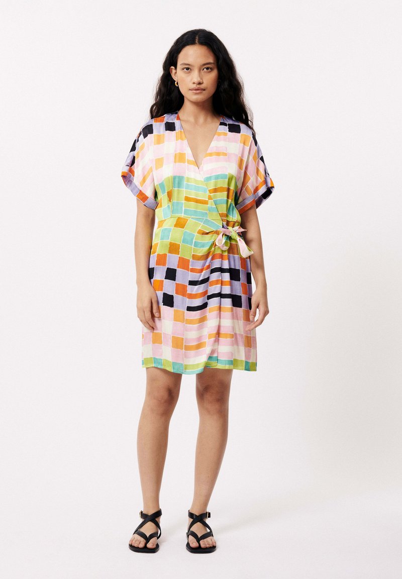 Kleurrijke patchwork jurk met brede mouwen, een V-hals en een strik in de taille. Bevat vierkanten in pastel- en levendige kleuren.