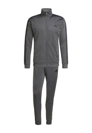 Chándal gris hecho de tela suave y ligera. La chaqueta tiene un cuello alto, cremallera completa en el frente y rayas negras en los costados. Los pantalones tienen puños elásticos.