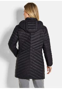 Zwarte gewatteerde jas met een chevron-gestikt ontwerp, capuchon en lange mouwen. Het materiaal heeft een gladde, glanzende textuur.