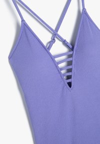 Lilla badetøj med V-halsdesign, struktureret stof og krydset stropdetalje bagpå. Har en slank, moderne silhuet.