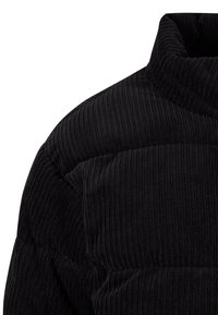 Mustast veluurriidest jakk kõrge kraega, millel on vertikaalne triibuline tekstuur ja polsterdatud osad. Õmbluste detailid rõhutavad disaini.