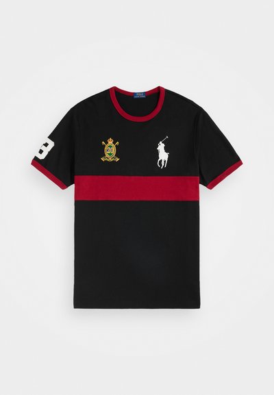 Črna polo majica z širokim rdečim vodoravnim pasom, rdečim ovratnikom in manšetami, belim številom 3 na rokavu, belim logotipom položnega igralca in zlatim grbom na prsih.