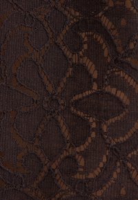 Tissu en dentelle marron foncé avec des motifs floraux et géométriques comprenant des zones en maille solide et ouverte cousues.