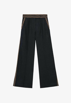 Pantaloni negri cu picior larg, cu margine zigzag maro de-a lungul taliei, cusăturilor laterale și buzunarelor, prezentați întinși pe un fundal alb.