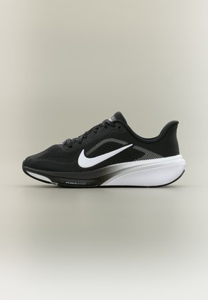 Zapatilla de running negra Nike con logo swoosh blanco, parte superior de malla transpirable y suela gruesa acolchada con tecnología Air Zoom.