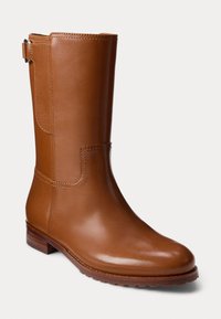 Brune lærstøvel til midten av leggen med en glatt overflate, avrundet tå og lav blokkhælt. Har søm-akenter og en sidestroppdetalj.