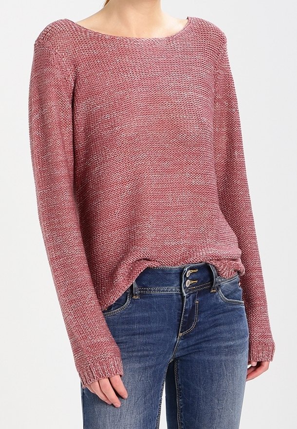 Pull en tricot de couleur rouge rose avec un grand col, des manches longues et des poignets côtelés, associé à un jean en denim bleu.