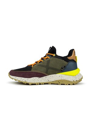 Zapatilla deportiva para hombre con parte superior de malla negra y paneles en oliva, cordones naranjas, acentos morados y una suela amarilla texturizada y con manchas.
