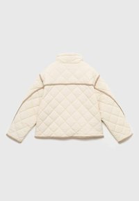 Veste matelassée crème avec un col haut, ornée de piping marron et d'un motif en losanges sur le dos et les manches.