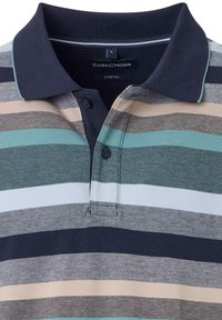 Striped polo shirt in shades of navy, green, beige, and white. Features a classic collar with two buttons and a woven texture. Brand label visible.