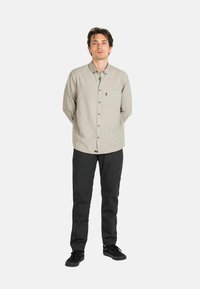 Long-sleeve gray button-up shirt with a chest pocket, paired with dark gray pants and black shoes. Simple design, classic fit.