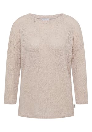 Beżowy, dziergany sweter z długim rękawem, o okrągłym dekolcie i małą białą metką marki na bocznym szwie.