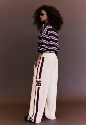 Bershka, WIDE-LEG EMBROIDERED PLUSH - TROUSERS - Pantaloni sportivi - beige