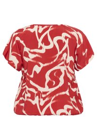 Blouse rouge à coupe ample avec un motif abstrait blanc. Fabriquée en tissu léger, elle possède des manches courtes et larges ainsi qu'un col rond.