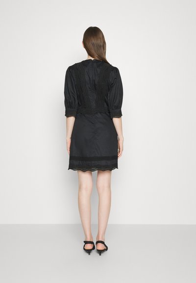 Μαύρο φόρεμα από σατέν με δαντελένιο τερματισμό, με κοντά φουσκωτά μανίκια, εφαρμοστή κορυφή και φαρδιά τελειώματα. Περιλαμβάνει και κυματιστό άκρο.