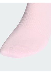 Světle růžová ponožka s žebrovanou texturou a hladkým povrchem. Má zaoblenou špičku a jemné stehování.