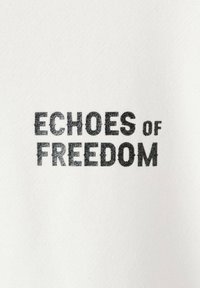 Material alb cu textul "ECHOES OF FREEDOM" scris cu litere negre îndrăznețe. Literele au un finisaj texturat, contrastând cu fundalul neted.