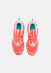 Nike trkačke tenisice s gornjim dijelom od svijetlo koraljne mreže, bijelim detaljima, tirkiznim unutarnjim oblogom, podstavljenim ovratnikom i kopčanjem na vezanje.