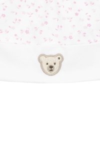 Casquette en coton blanc avec un bord replié, ornée d'un motif floral rose et d'un petit visage de ours polaire brodé sur le devant.