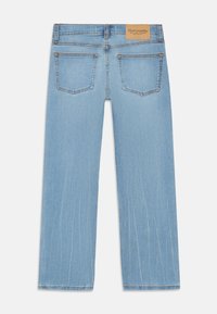 Jasnoniebieskie jeansy o prostym kroju, wykonane z denimu, z dwiema tylnymi kieszeniami, widocznym szyciem i brązową skórzaną metką marki na pasku.