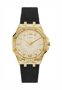 Hodinky v barvě zlata s texturovaným černým řemínkem, osmihranným pouzdrem, lunetou zdobenou krystaly a ciferníkem posetým drahokamy s velkými hodinovými značkami.