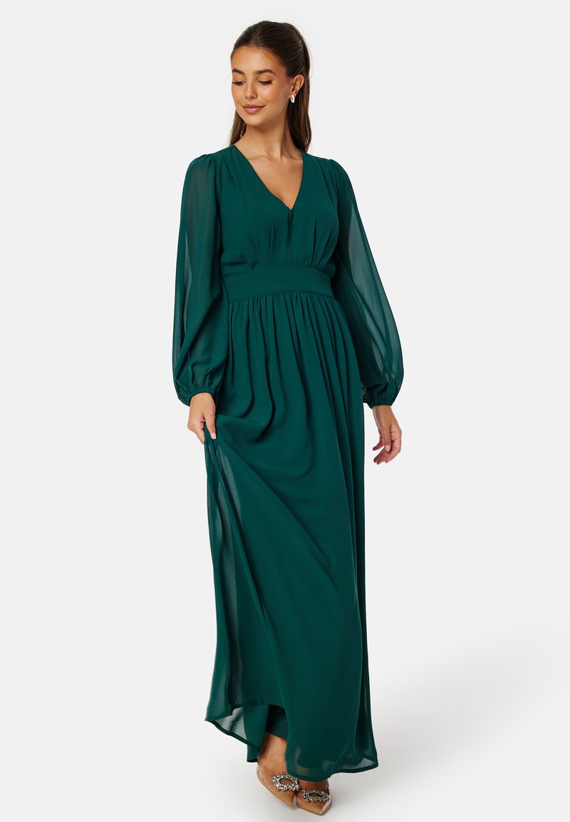 Langes, fließendes grünes Kleid aus leichtem Stoff, mit V-Ausschnitt, Ballonärmeln und einem taillierten Bund mit Falten.