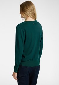 Groen gebreide pullover met een ronde halslijn, lange mouwen en knoopaccenten op de manchetten. Ribgebreide zoom en zachte textuur.