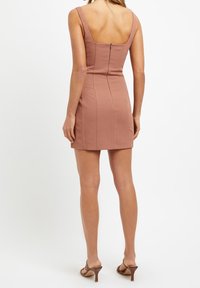 Robe sans manches ajustée en tissu rose poussiéreux doux, avec un décolleté carré à l'arrière et une fermeture éclair dissimulée. Texture lisse et longueur mini.