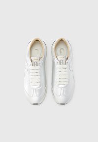 Ασημένια αθλητικά παπούτσια με λείο, μεταλλικό φινίρισμα, λευκά κορδόνια, διακριτικές ραφές και επενδυμένο εσωτερικό πάτο.