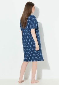 Modré šaty s krátkými rukávy a délka ke kolenům. Vzor s kulatými motivy na tmavě modrém pozadí. Vyrobeno z měkké látky.