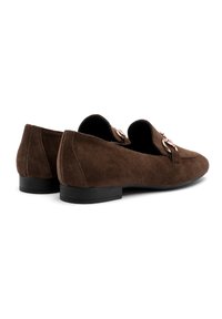 Mocassini in suede marrone con tacco basso nero, caratterizzati da dettagli in metallo decorativi sulla parte anteriore. Tessuto liscio con un design semplice.