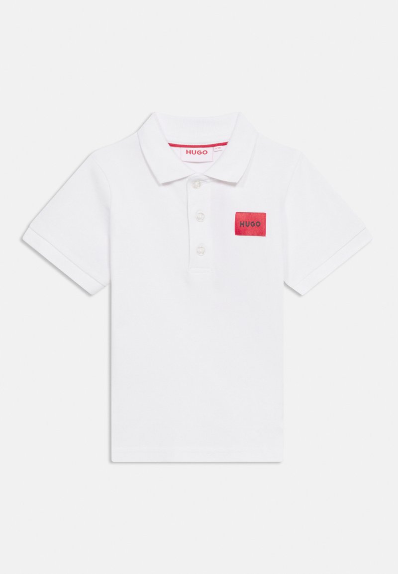 Λευκό πόλο πουκάμισο με κοντά μανίκια, τρία κουμπιά στο μπροστινό μέρος και κόκκινο ορθογώνιο αυτοκόλλητο με την ένδειξη "HUGO" στο αριστερό στήθος.