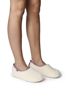 Witte fleece slippers met een zachte, donzige textuur, ronde vorm en een decoratieve rode en witte patroon trim langs de opening.