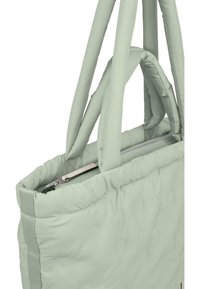 Vatteret totebag i lysegrønt stof med polstrede håndtag og en lynlåslukning øverst. Bemærkelsesværdig metal lynlåstræk detalje synlig.