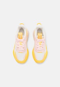 Weiße Sneakers mit pinken Akzenten und gelben Sohlen. Besitzen ein Obermaterial aus Mesh, eine runde Zehenpartie und ein Schnürdesign. Puma-Logo auf der Zunge.