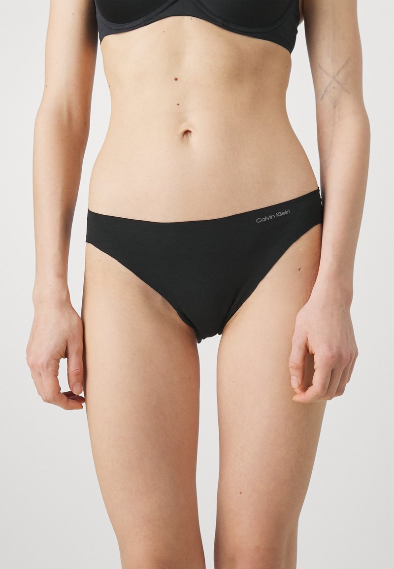 Black cotton bikini briefs with a low-rise silhouette and logo detail on the waistband. Smooth texture and minimalist design.