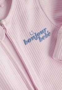 Body bébé côtelé rose doux avec le texte bleu "bonjour bébé" et un petit visage souriant au-dessus des mots.