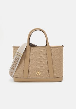 Beżowa torba typu tote Michael Kors z wytłaczanym wzorem logo, skórzanymi wykończeniami, dwoma uchwytami oraz regulowanym materiałowym paskiem na ramię z nazwą marki.