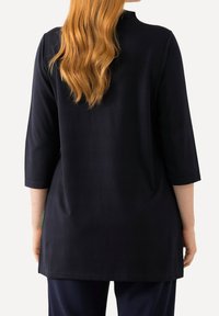 Navyblaue Tunika, ¾-Ärmel, leicht lockerer Schnitt, knielang, aus weichem Stoff, mit rundem Halsausschnitt und minimalistischem Design.