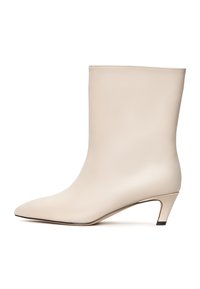 Botine din piele bej cu vârf ascuțit și toc conic. Textură netedă, cu cusături minime și o siluetă elegantă.
