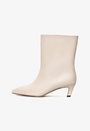 Beige leather ankle boot with a pointed toe and a conical heel. Smooth texture with minimal stitching and a sleek silhouette.