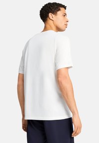 Witte katoenen t-shirt met korte mouwen, ronde hals en een losse pasvorm. Soepele textuur zonder zichtbare patronen of versieringen.